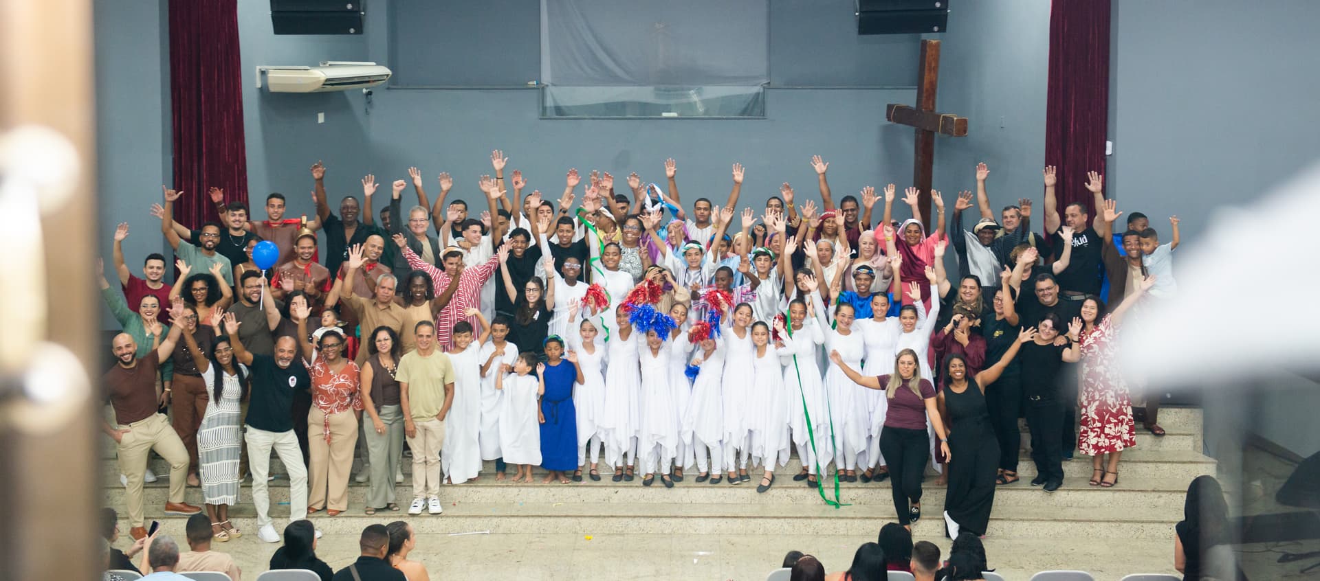 Congregação da IBVER reunida em frente à cruz do santuário, com as mãos erguidas em celebração