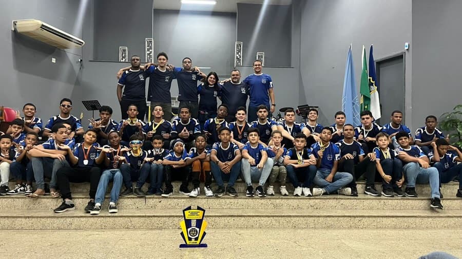 Time dos Embaixadores do Rei reunido no templo com medalhas e troféu de campeonato