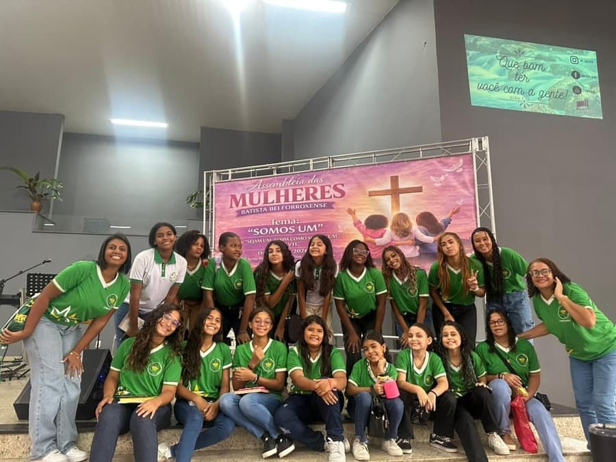 Meninas das Mensageiras do Rei com o uniforme verde do ministério em evento na igreja