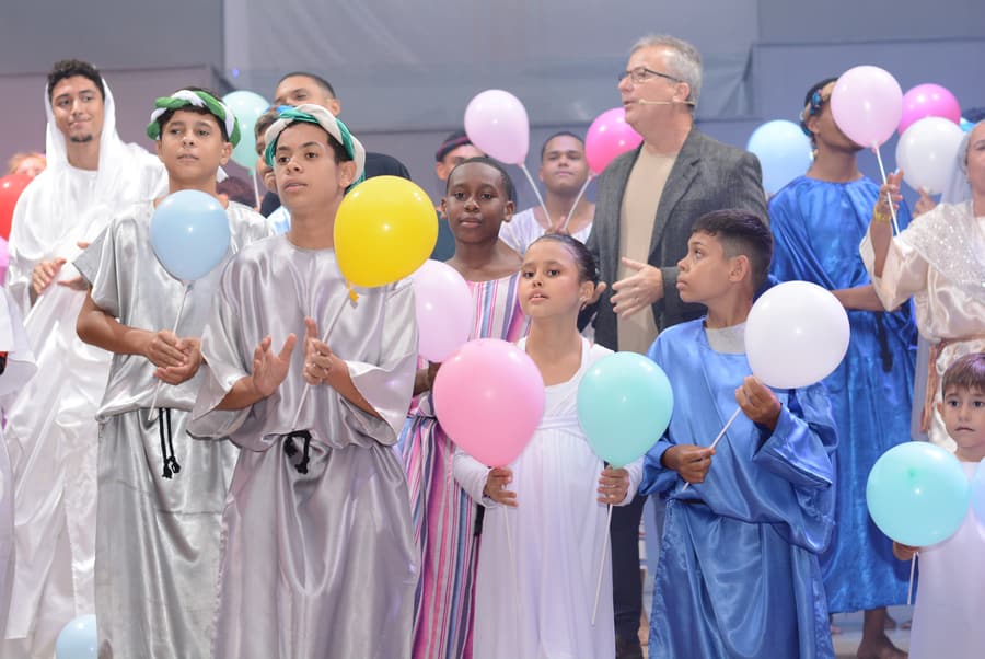 Adolescentes do Projeto Semente reunidos no palco durante apresentação da igreja